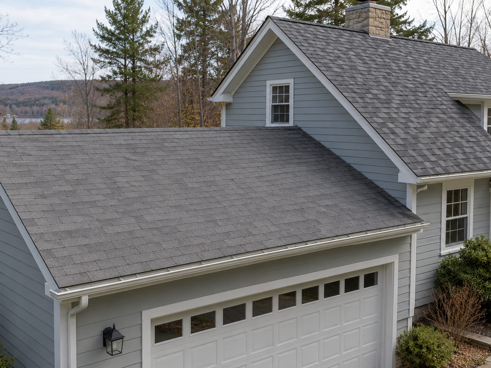 Two connected roof sections on a house, one with flat three-tab shingles and one with thicker architectural shingles