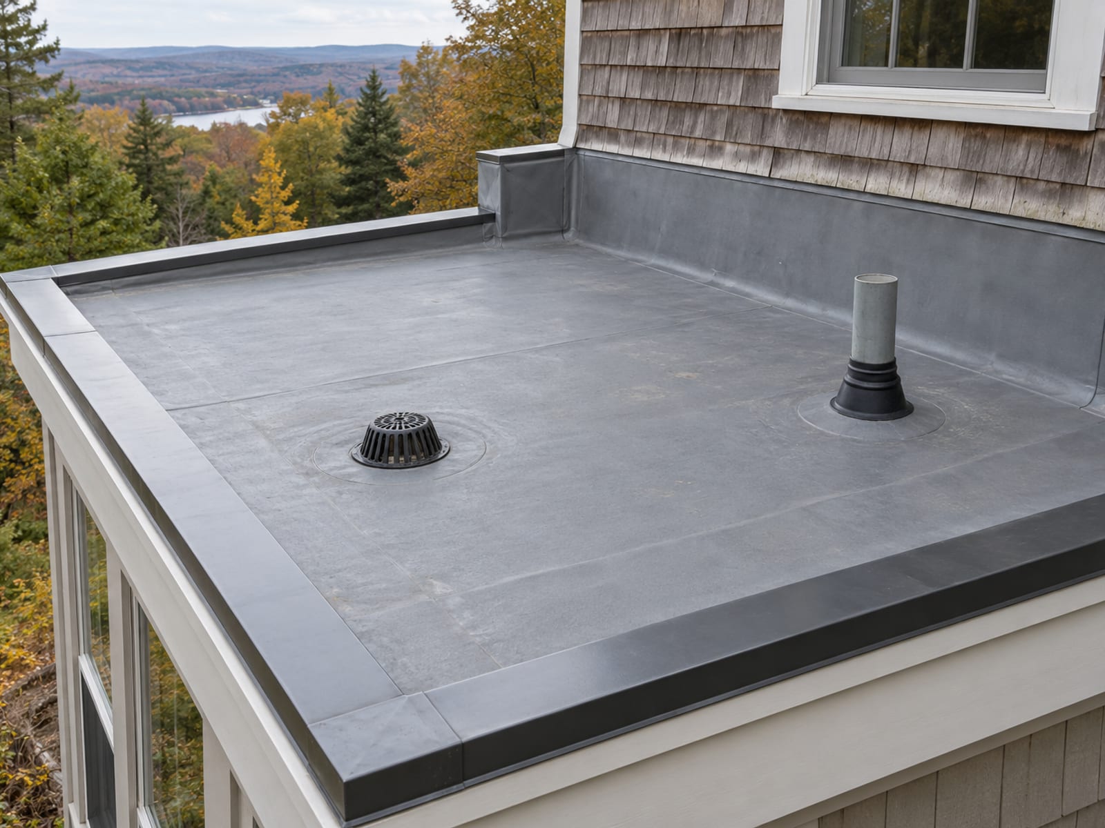Small low-slope addition roof seen from above with corner edge metal, wall flashing, a drain and a vent pipe packed into a small area