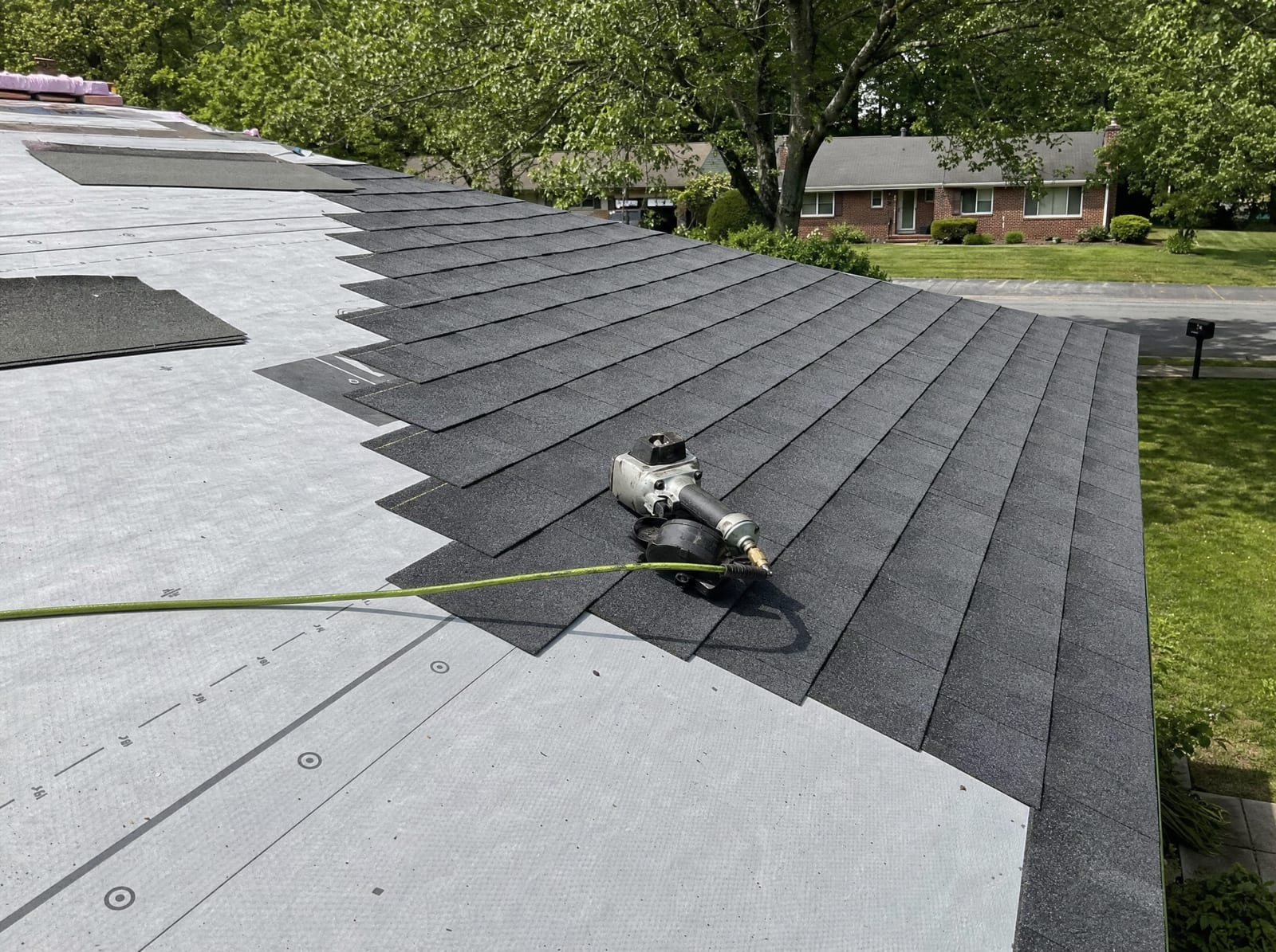 Architectural shingles installed in even courses over new underlayment on a ranch roof