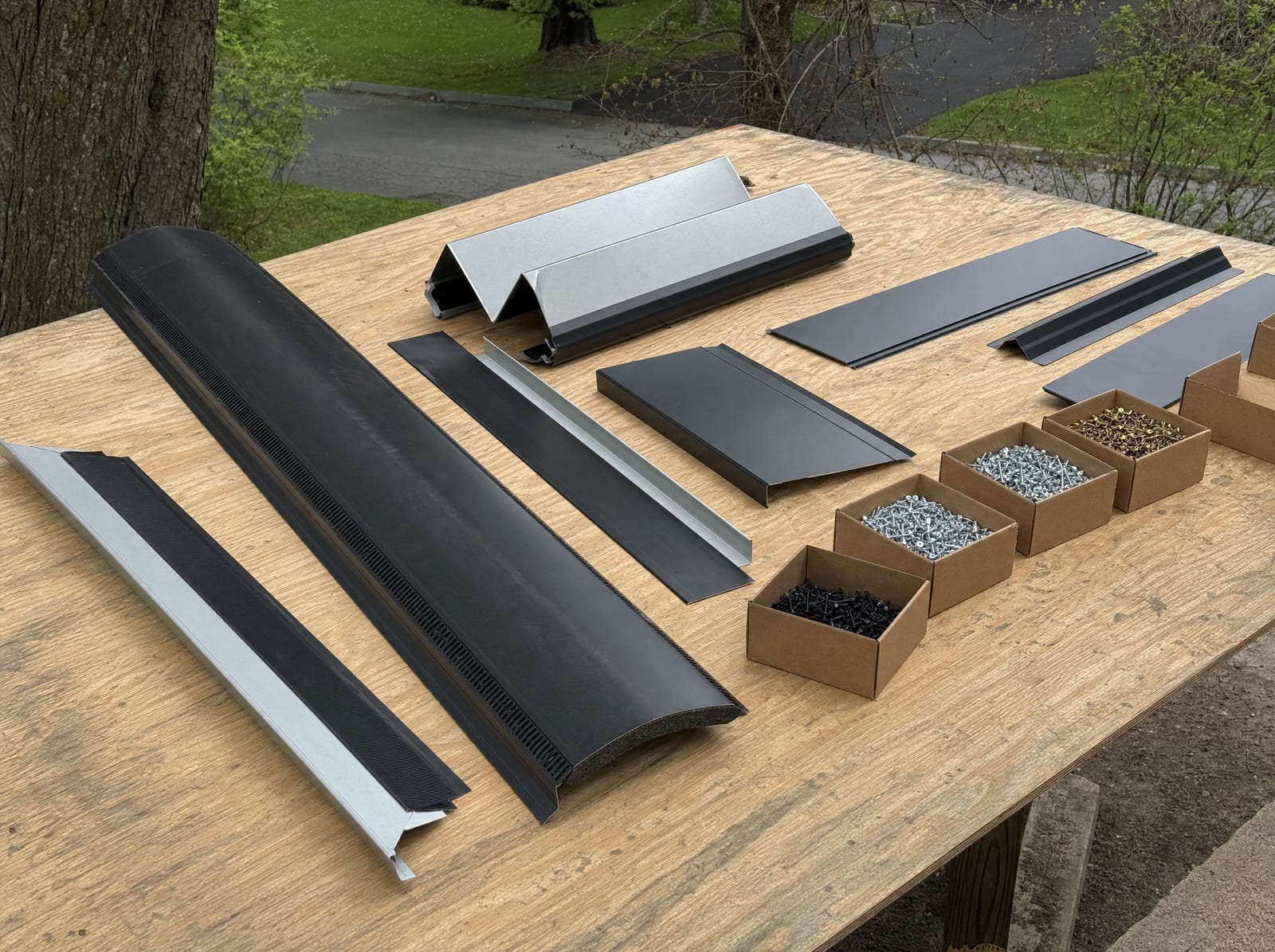Roofing flashing, ridge vent, and fasteners laid out neatly like a checklist