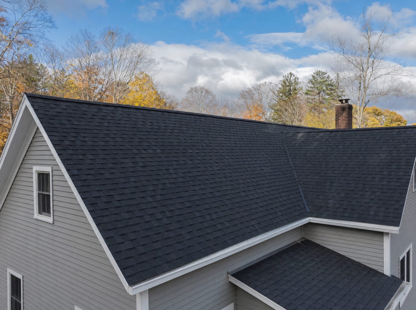 Finished steep-pitch roof with clean ridge line, valleys, and flashing