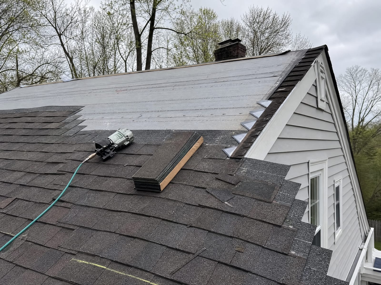 Roofing crew installing new architectural asphalt shingles on a Brookfield, Connecticut home during a roof replacement