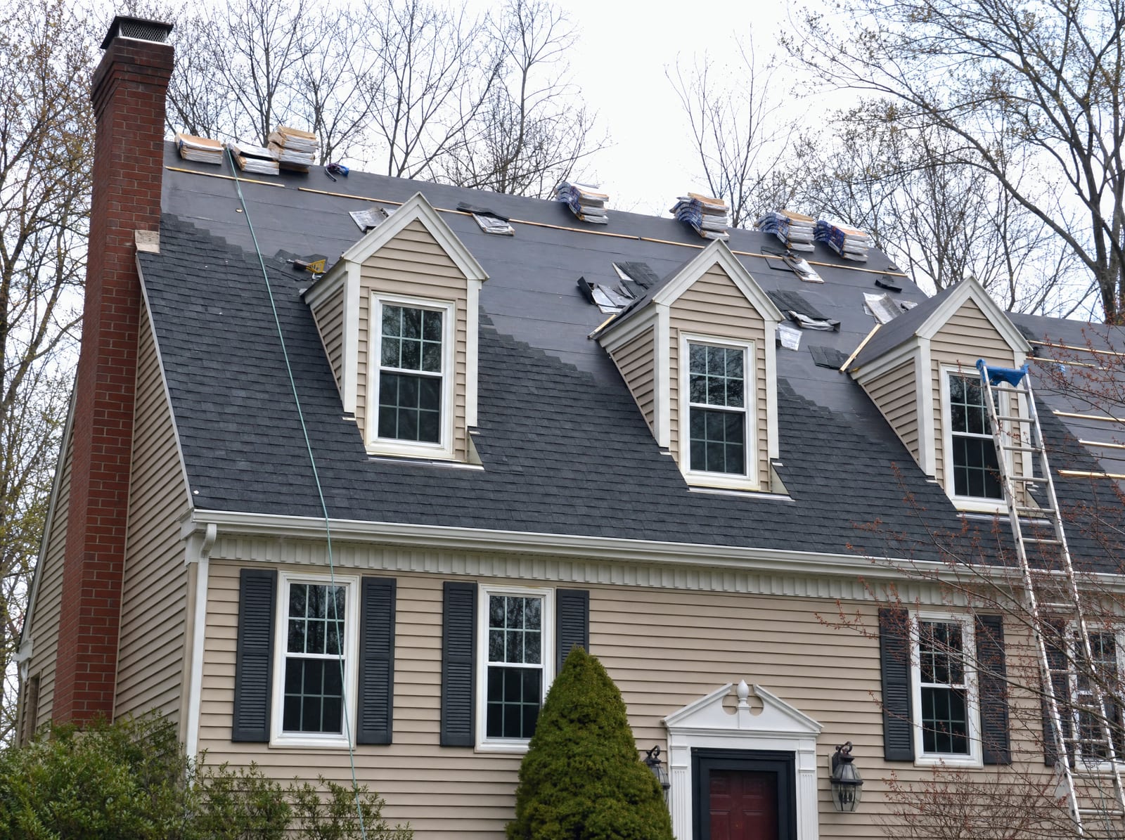 New shingles installed course by course over underlayment on a colonial roof