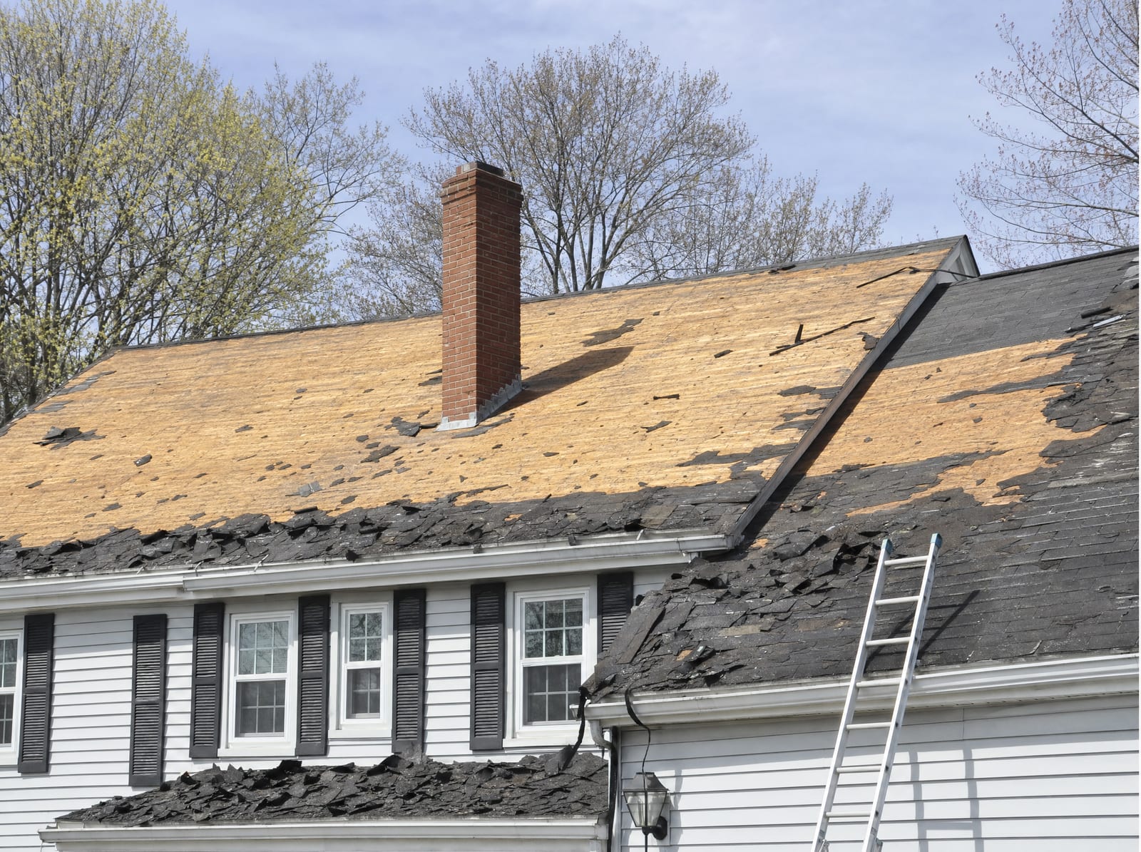 Tear-off in progress, old shingles removed to expose the roof decking