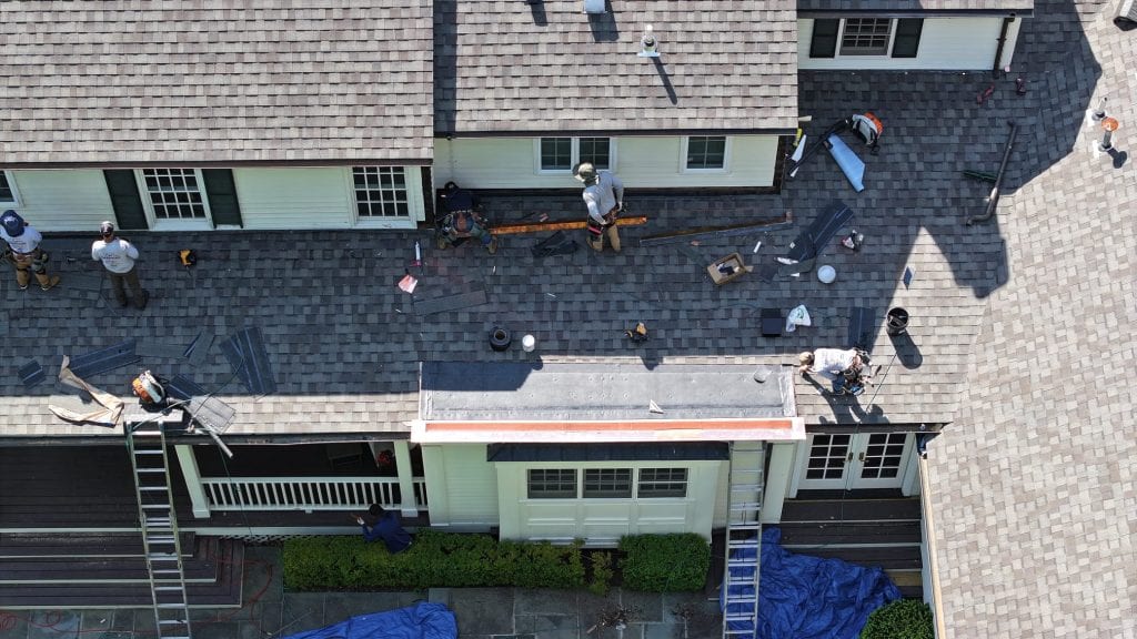 Roofing crew installing a new asphalt shingle roof on a Central Connecticut home, aerial view